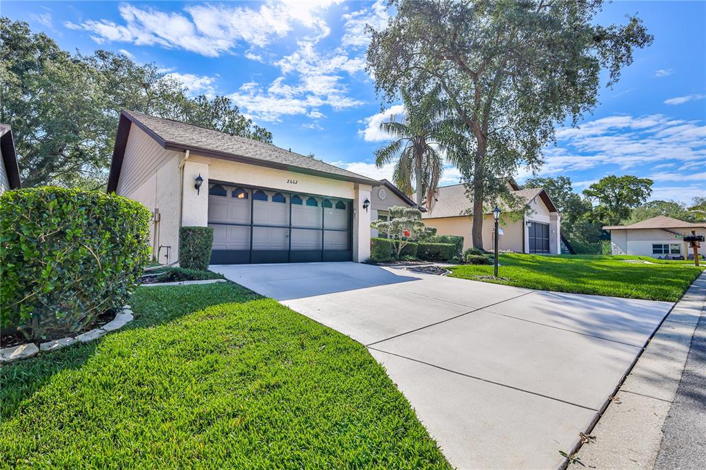 A single-story house with a two-car garage, a concrete driveway, and a manicured lawn — 2662 APPLELEAF COURT, SPRING HILL, FL