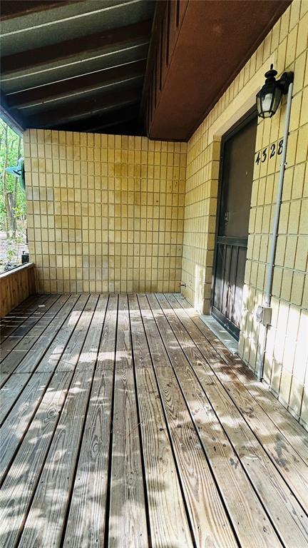 A wooden deck leads to a screen door on a brick building exterior — 4328 SW 69TH TERRACE, GAINESVILLE, FL