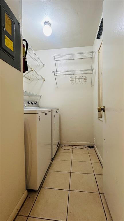 A laundry room features white appliances, wire shelving, and light-colored tile flooring — 4328 SW 69TH TERRACE, GAINESVILLE, FL