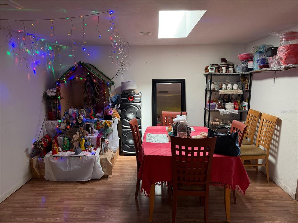 A dining room features a red tablecloth, wooden chairs, and a large religious display — 2300 SMITH ROAD, HAINES CITY, FL
