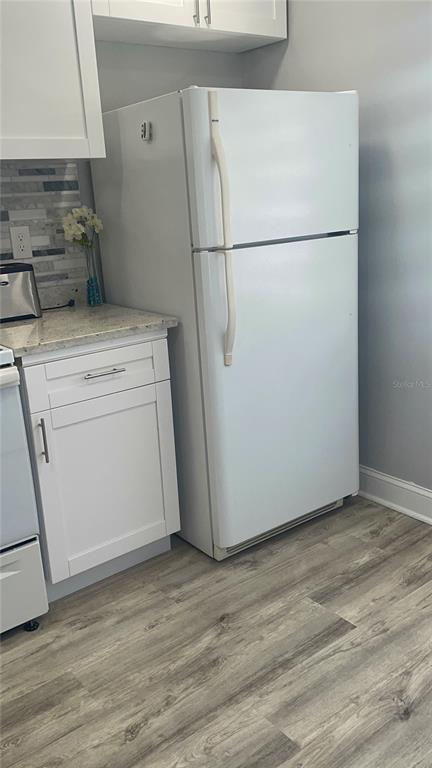 A white refrigerator stands next to a white cabinet with a granite countertop — 5724 LA PUERTA DEL SOL BOULEVARD UNIT 248, ST PETERSBURG, FL