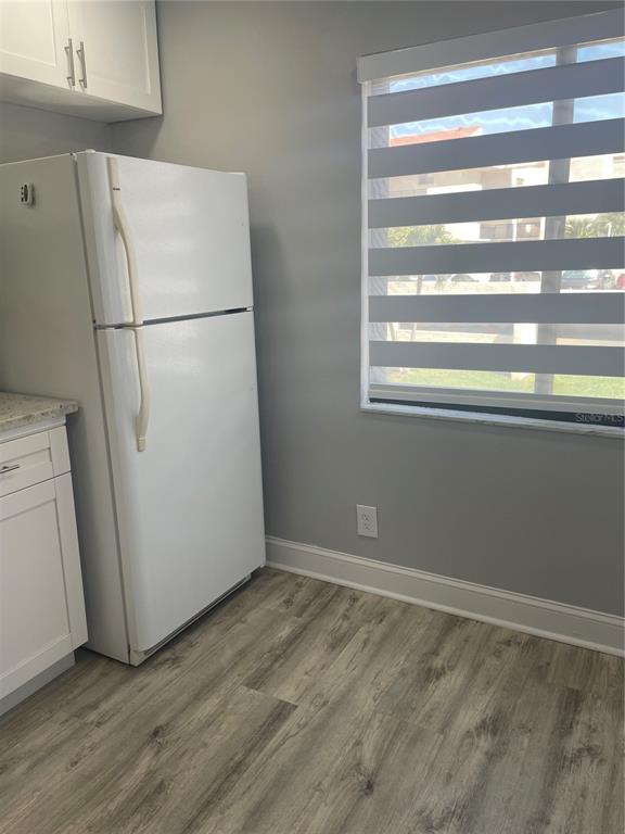 A white refrigerator stands in a kitchen with gray walls, light flooring, and a window — 5724 LA PUERTA DEL SOL BOULEVARD UNIT 248, ST PETERSBURG, FL