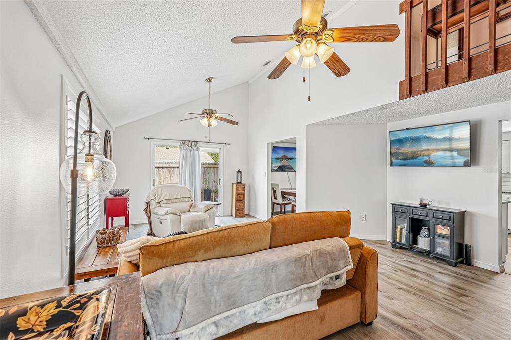 A wooden walkway leads to a brown front door with a decorative glass oval insert — 5102 MOELLER AVENUE, SARASOTA, FL