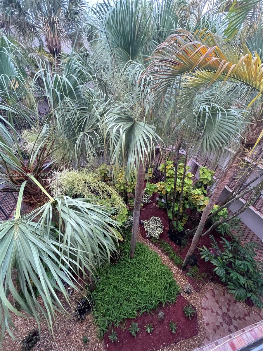 An elevated view shows a lush courtyard garden with palm trees and landscaped flower beds — 8400 SW 133rd Ave Rd # 424, Miami FL 33183, MIAMI, FL