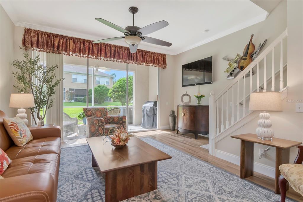 A living room features a leather sofa, a wooden coffee table, and a sliding glass door — 4111 BISMARCK PALM DRIVE, TAMPA, FL