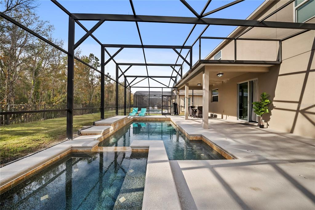 A screened-in patio features a rectangular swimming pool with an attached spa and concrete decking — 4736 BLUE DIAMOND STREET, KISSIMMEE, FL