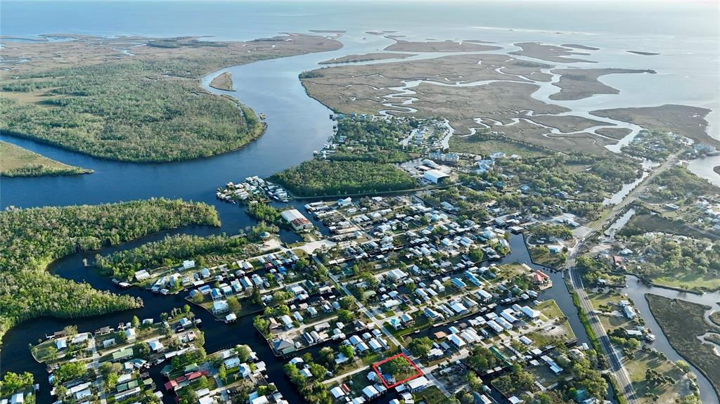 An aerial view shows a coastal residential community with a red-outlined property lot — 249 SE 228 STREET, SUWANNEE, FL