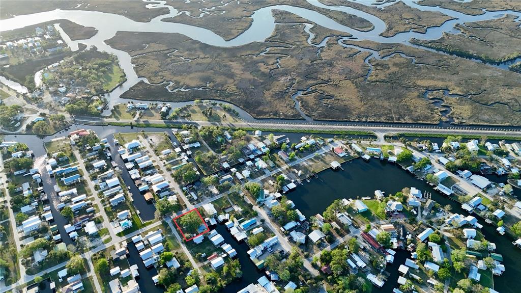 Aerial view of a residential neighborhood with a red-outlined property near a marshy waterway — 249 SE 228 STREET, SUWANNEE, FL