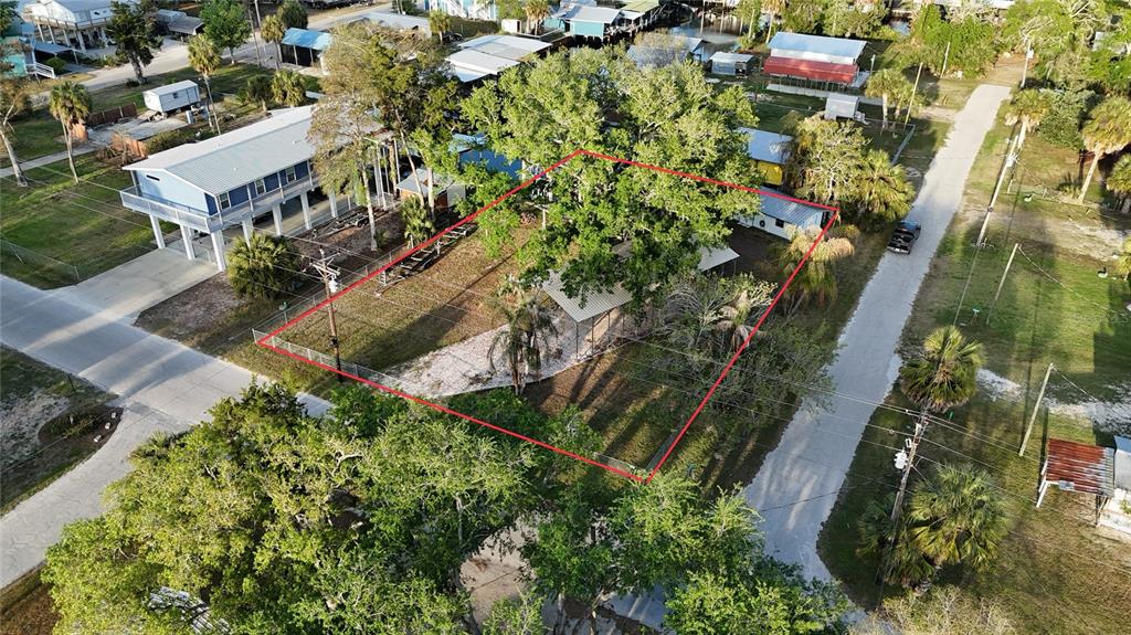 An aerial view shows a fenced residential lot with a large tree and small structure — 249 SE 228 STREET, SUWANNEE, FL