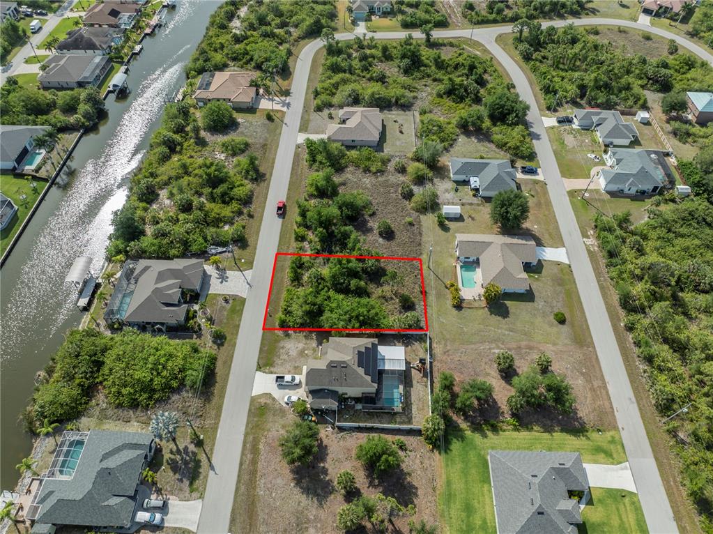 An aerial view shows a vacant rectangular lot outlined in red between two residential streets — 14337 EDNA CIRCLE, PORT CHARLOTTE, FL
