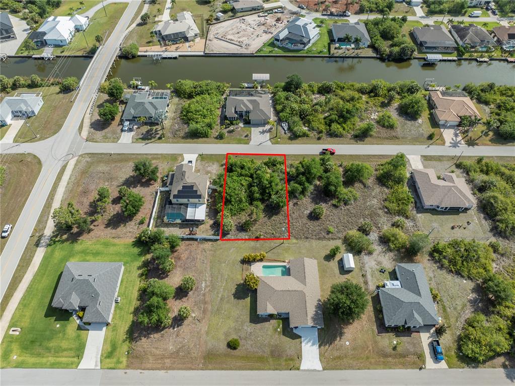 An aerial view shows a vacant, rectangular lot outlined in red within a residential neighborhood — 14337 EDNA CIRCLE, PORT CHARLOTTE, FL