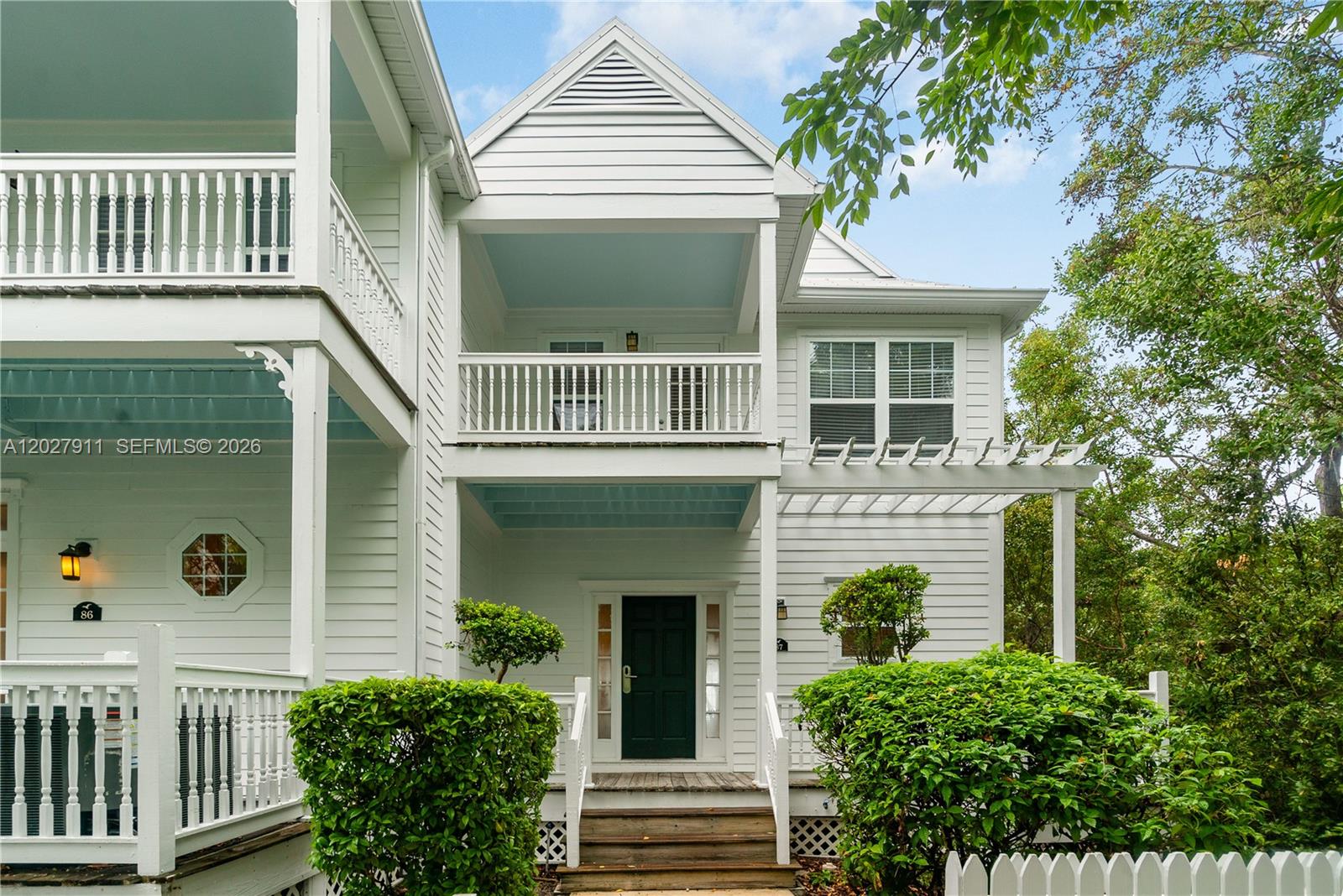 A white two-story house features a front porch, a balcony, and a dark green door — 2600 Overseas Hwy # 87, Marathon FL 33050, MARATHON, FL