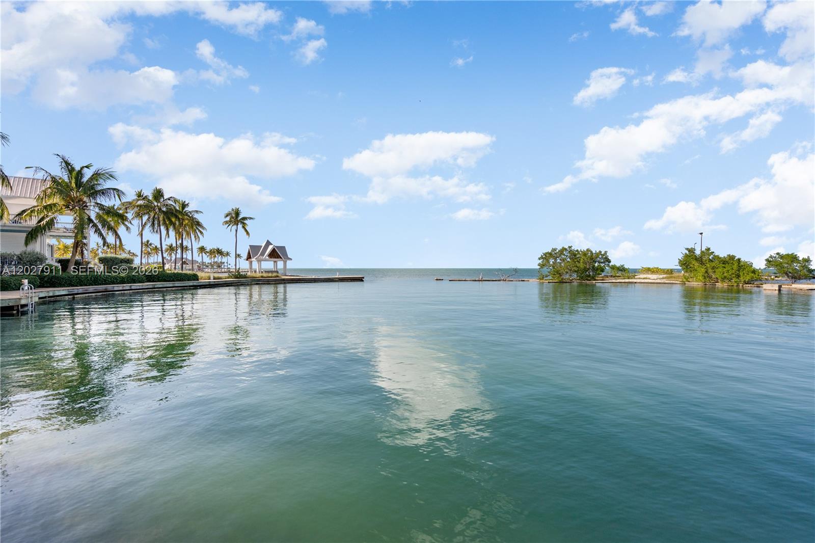A view of a calm bay with a gazebo, palm trees, and a wooden dock — 2600 Overseas Hwy # 87, Marathon FL 33050, MARATHON, FL