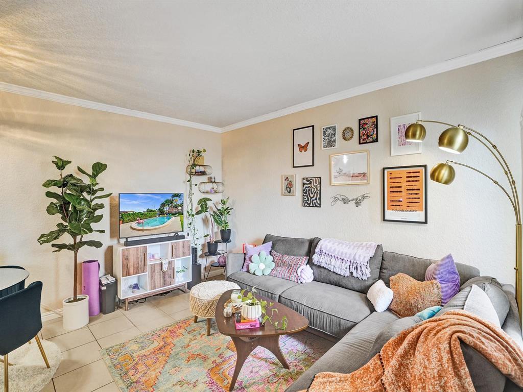 A living room features a grey sectional sofa, a colorful area rug, and a gallery wall — 2190 SE 5th Street # a, Pompano Beach FL 33062, POMPANO BEACH, FL