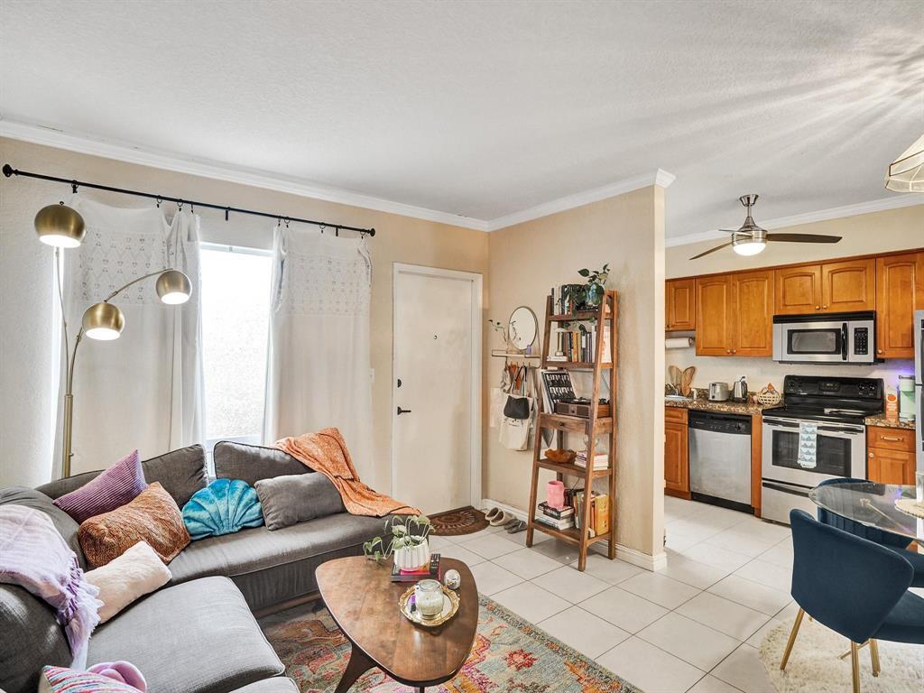 A living room with a gray sectional sofa flows into an open kitchen with wood cabinets — 2190 SE 5th Street # a, Pompano Beach FL 33062, POMPANO BEACH, FL