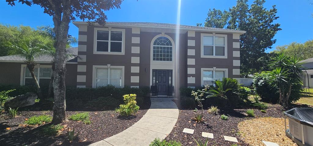 A two-story house with a brown exterior, white corner accents, and a central arched window — 921 WESTCLIFFE DRIVE, WINTER GARDEN, FL