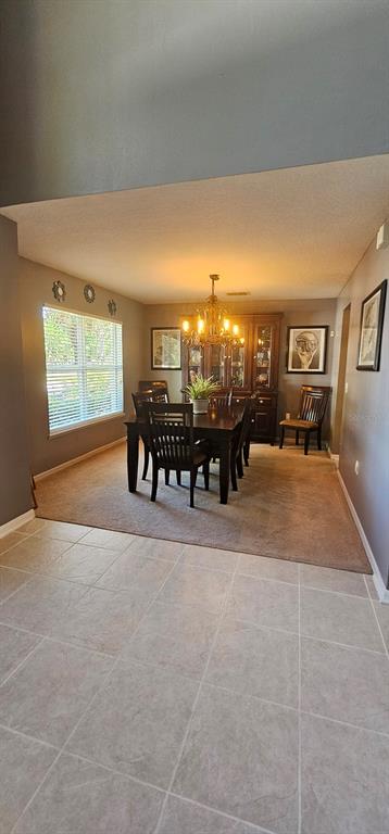 A dining room features a dark wood table and chairs on carpeted flooring — 921 WESTCLIFFE DRIVE, WINTER GARDEN, FL