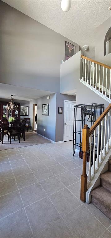 A foyer with tile flooring leads to a dining area and a carpeted staircase — 921 WESTCLIFFE DRIVE, WINTER GARDEN, FL