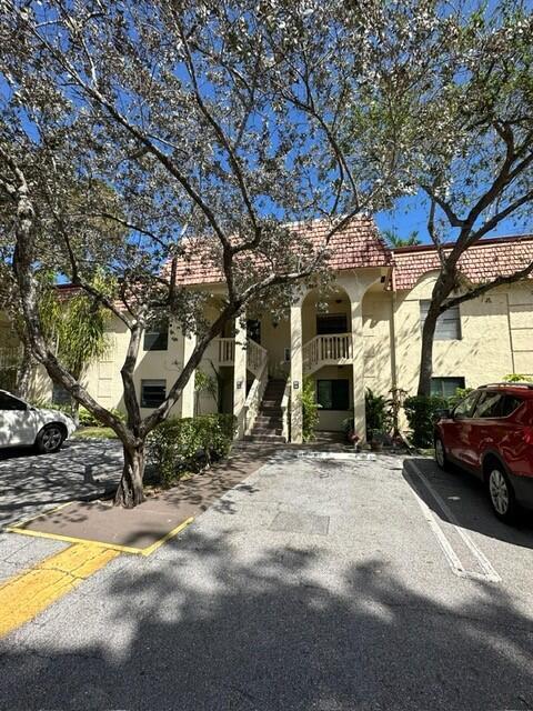 A two-story apartment building with a red tile roof and a central outdoor staircase — 132 S Cypress Road # 523, Pompano Beach FL 33060, POMPANO BEACH, FL