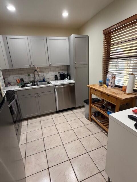 A kitchen features gray cabinets, a stainless steel dishwasher, and a wooden rolling kitchen island — 132 S Cypress Road # 523, Pompano Beach FL 33060, POMPANO BEACH, FL