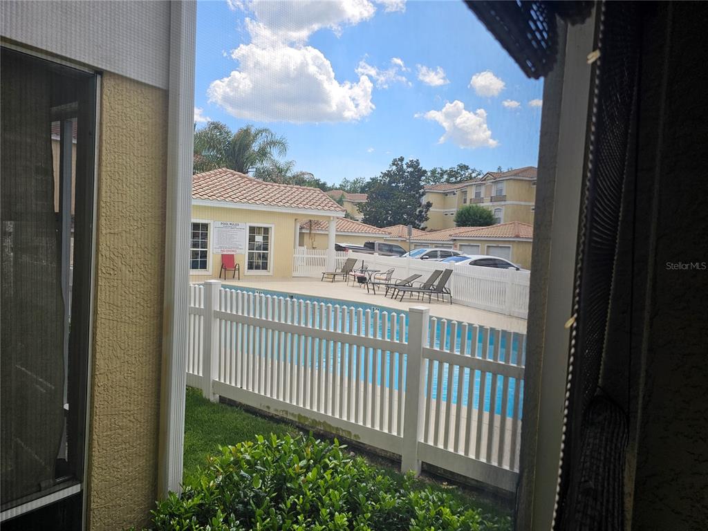 A view from a screened porch overlooking a community swimming pool and surrounding apartment buildings — 673 SANDY NECK LANE UNIT 103, ALTAMONTE SPRINGS, FL