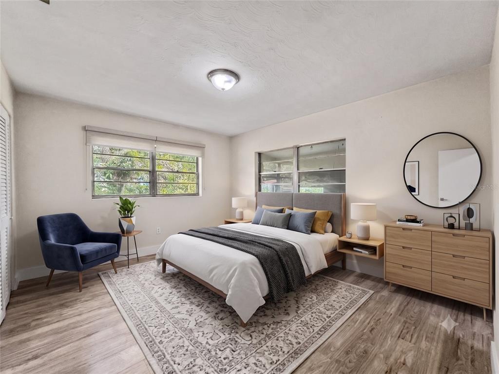 A kitchen with white cabinets and appliances opens into a spacious, light-filled living area — 3502 ARCH STREET, ORLANDO, FL