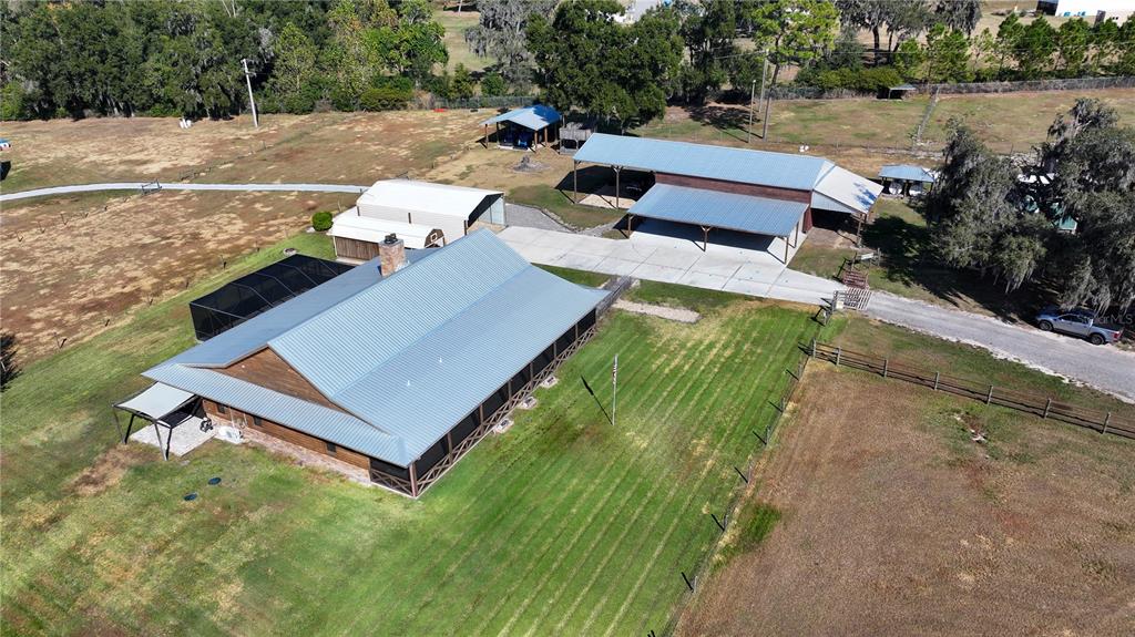 An aerial view shows a house with a metal roof, outbuildings, and a large yard — 3182 INDIAN RIDGE PLACE, LAKELAND, FL
