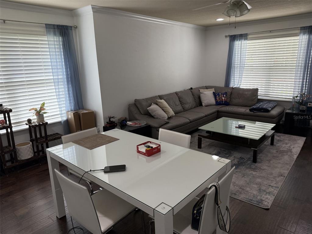 A dining area with a white table sits in front of a living room with a sectional — 4639 SW 48TH DRIVE UNIT 149, GAINESVILLE, FL