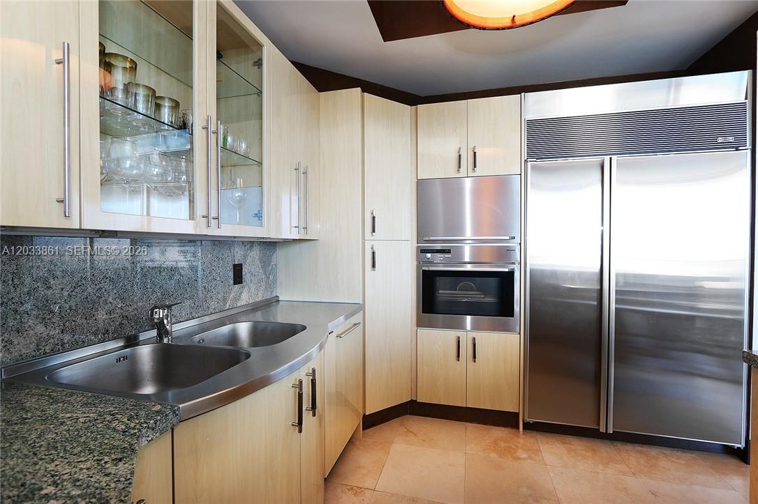 A kitchen features light wood cabinets, stainless steel appliances, and granite countertops — 100 S Pointe Dr # 601, Miami Beach FL 33139, MIAMI BEACH, FL