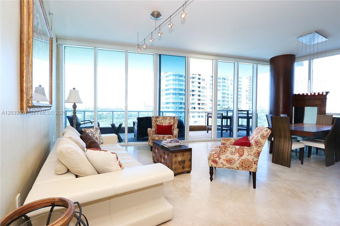 A living and dining area features floor-to-ceiling windows, tile flooring, and a balcony view — 100 S Pointe Dr # 601, Miami Beach FL 33139, MIAMI BEACH, FL
