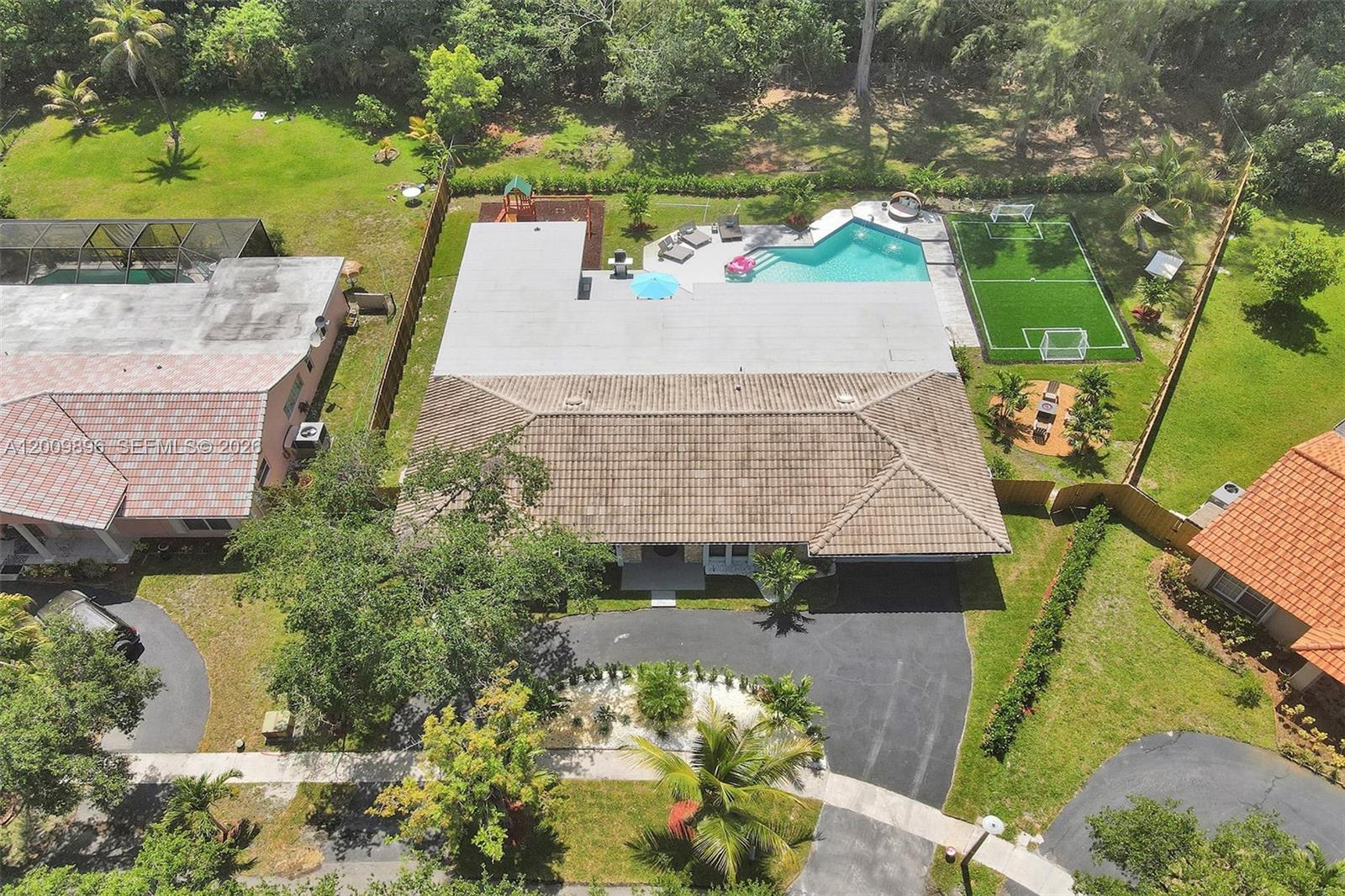 An aerial view shows a house with a tiled roof, swimming pool, and soccer field — 1960 SW 51st Ter, Plantation FL 33317, PLANTATION, FL