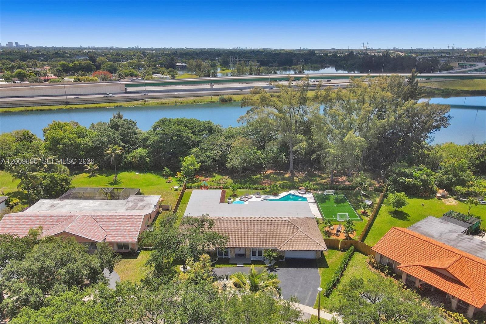 An aerial view shows a house with a pool and soccer field near a highway — 1960 SW 51st Ter, Plantation FL 33317, PLANTATION, FL