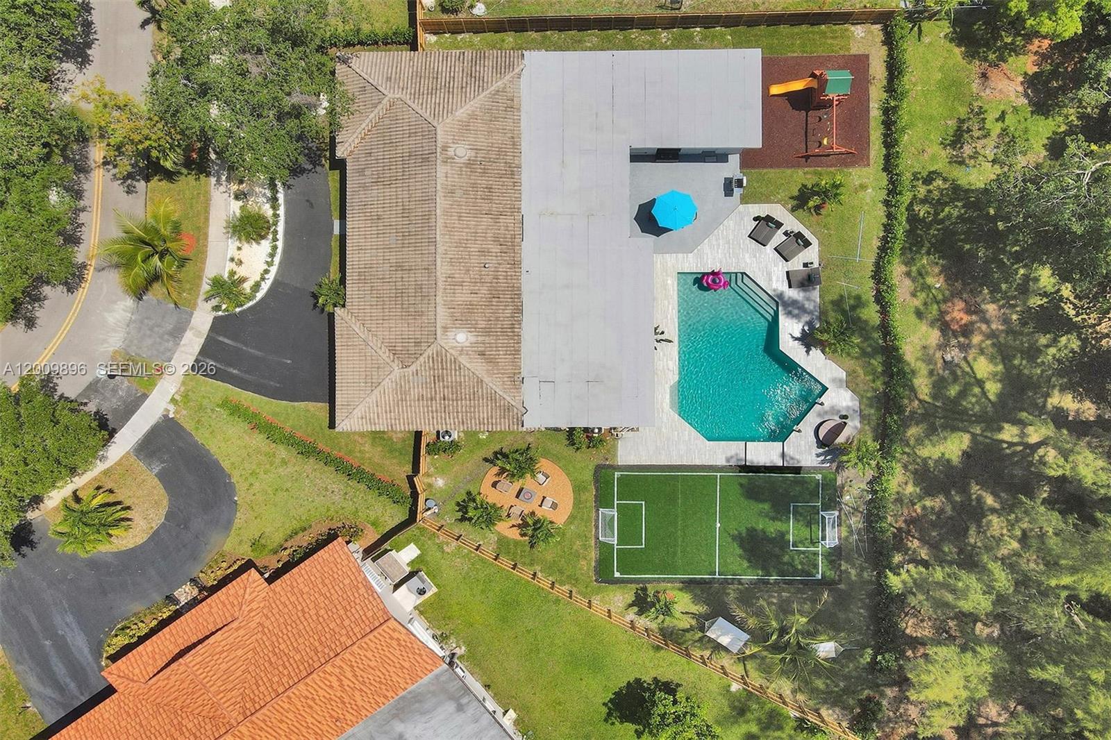 An aerial view shows a house with a pool, soccer field, and playground in the backyard — 1960 SW 51st Ter, Plantation FL 33317, PLANTATION, FL