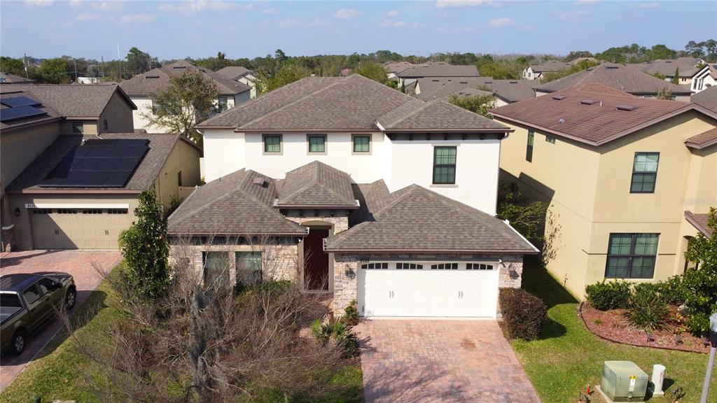 An aerial view of a two-story suburban house with a stone facade and attached garage — 5115 TIBER WAY, ST CLOUD, FL