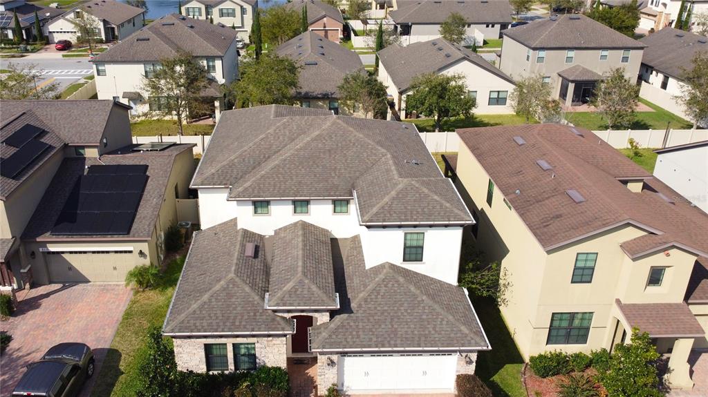 An aerial view shows a two-story suburban house with a shingled roof and white exterior — 5115 TIBER WAY, ST CLOUD, FL
