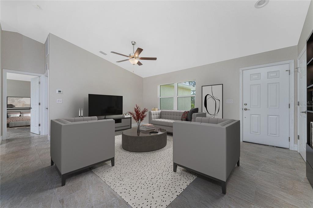 A living room features gray furniture, a round coffee table, and tile flooring — 1425 LINDSAY AVENUE, NORTH PORT, FL