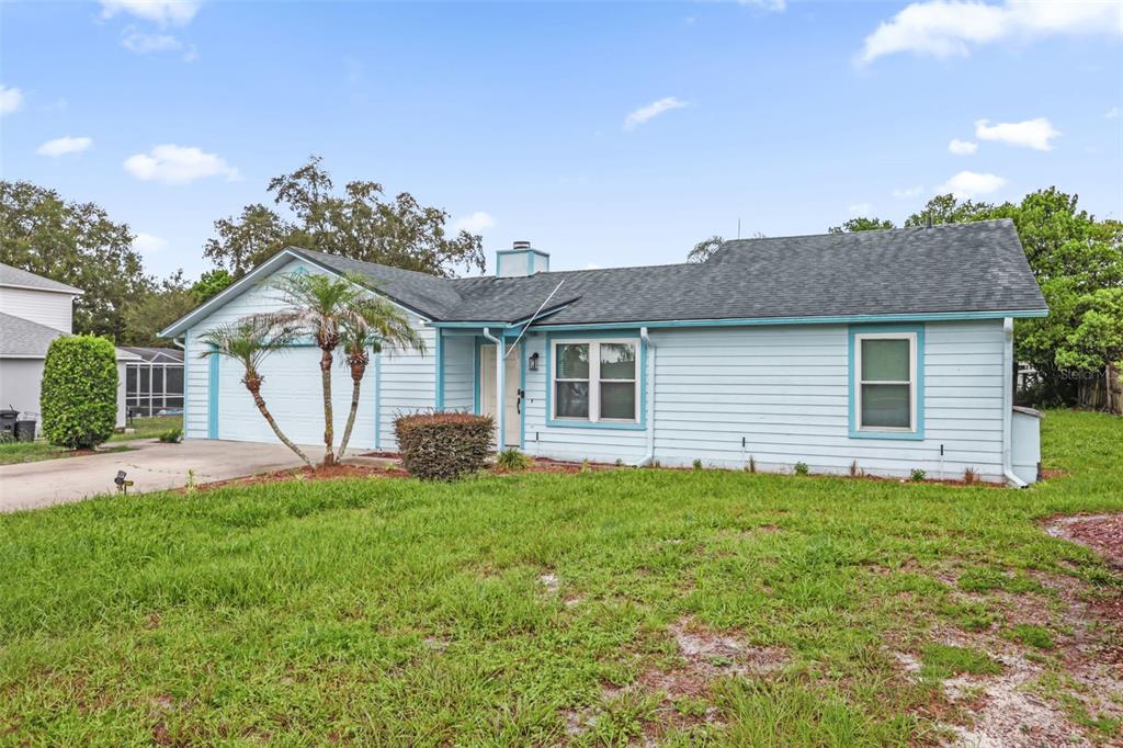 A light blue, single-story house with a two-car garage and a front lawn — 1762 HOWLAND BOULEVARD, DELTONA, FL