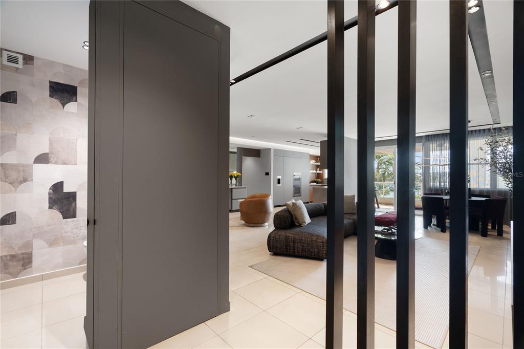 A view from a hallway into a modern living room with a dark wood slat partition — 592 TTE CESAR GONALEZ AVE, TORRE CIBELES, TORRE I AVENUE UNIT 213, SAN JUAN, PR