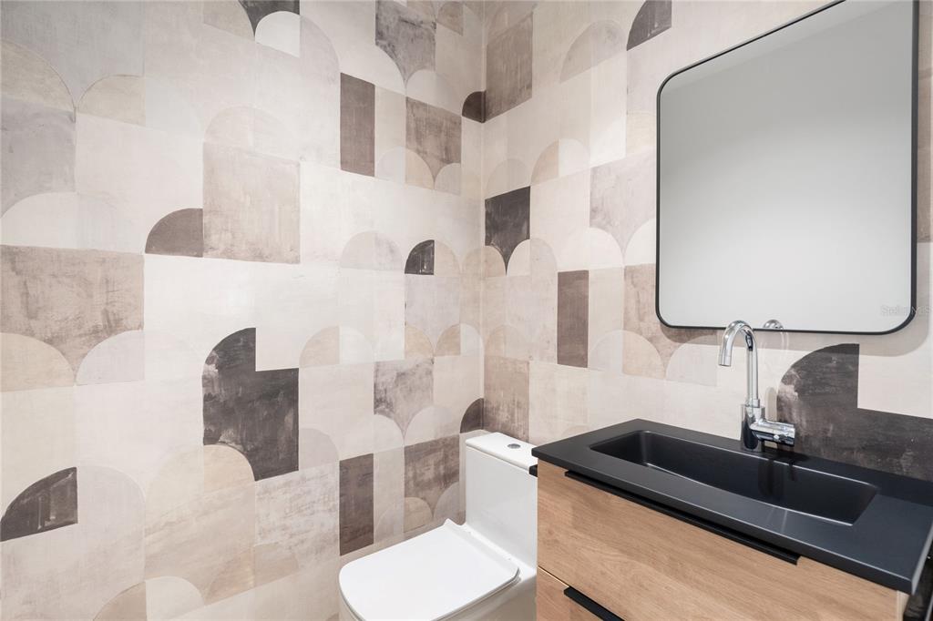 A modern powder room features geometric patterned wallpaper, a black vanity, and a rectangular mirror — 592 TTE CESAR GONALEZ AVE, TORRE CIBELES, TORRE I AVENUE UNIT 213, SAN JUAN, PR
