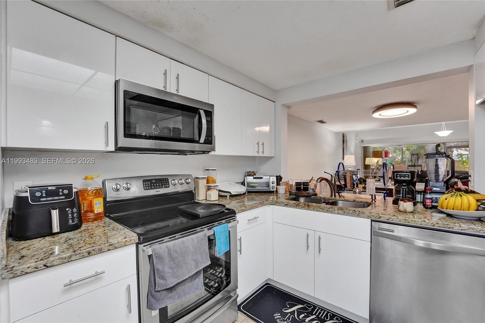 A kitchen features white cabinets, stainless steel appliances, and granite countertops — 3592 NW 83rd Ln, Sunrise FL 33351, SUNRISE, FL