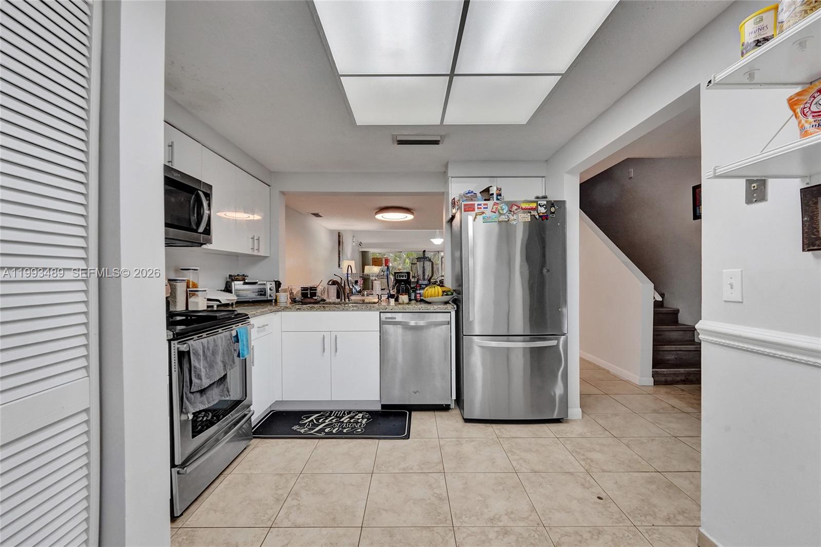 A kitchen features white cabinets, stainless steel appliances, and tile flooring — 3592 NW 83rd Ln, Sunrise FL 33351, SUNRISE, FL
