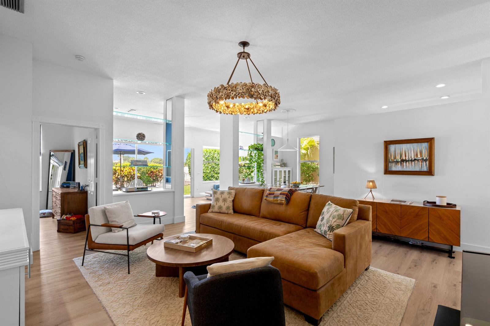 A living room features a brown sectional sofa, a round coffee table, and a chandelier — 1205 Gator Trail, West Palm Beach FL 33409, WEST PALM BEACH, FL