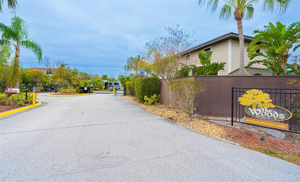 The entrance to The Woods RV Resort features a paved driveway, gate, and signage — 6841 AMANDA VISTA CIRCLE, LAND O LAKES, FL