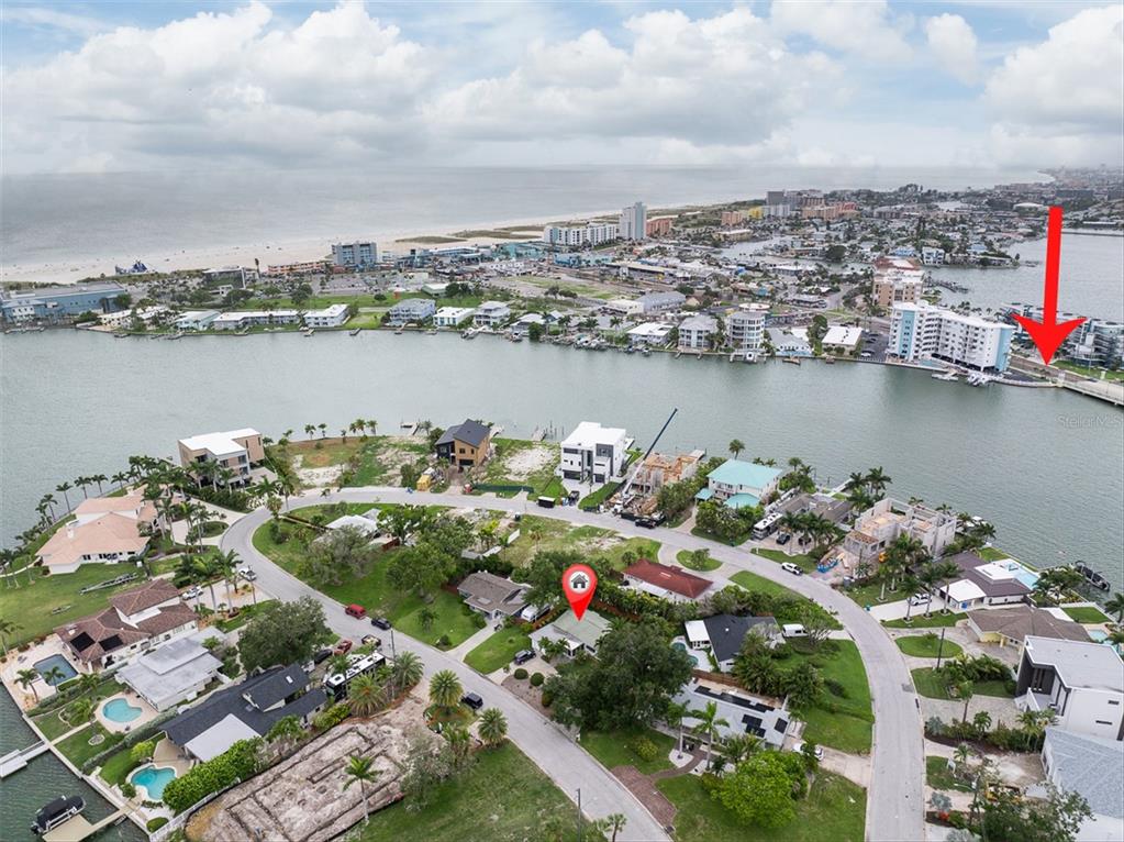 An aerial view shows a residential neighborhood near a waterway with a red location marker — 55A DOLPHIN DRIVE, TREASURE ISLAND, FL