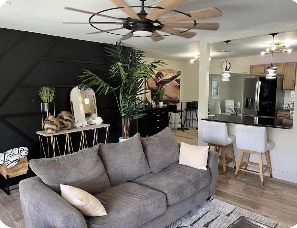 A living room features a black accent wall, gray sofa, and a ceiling fan — 511 SE 5th Street SE, Pompano Beach FL 33060, POMPANO BEACH, FL