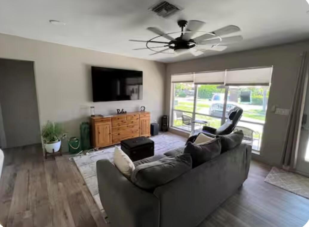 A living room features a grey sofa, a wooden media console, and a ceiling fan — 511 SE 5th Street SE, Pompano Beach FL 33060, POMPANO BEACH, FL