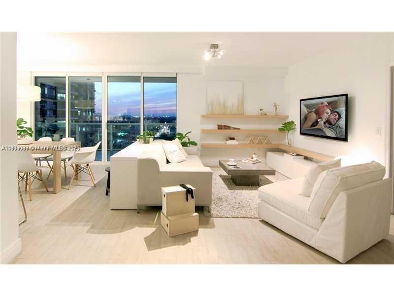 A modern living room features a white sofa, a coffee table, and a dining area — 1250 S Miami Ave # 901, Miami FL 33130, MIAMI, FL