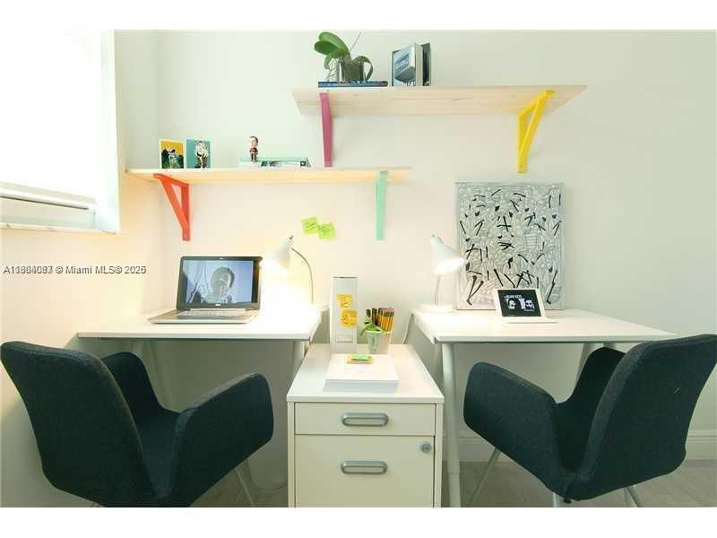 A home office features two white desks, dark chairs, and colorful wall-mounted shelving — 1250 S Miami Ave # 901, Miami FL 33130, MIAMI, FL