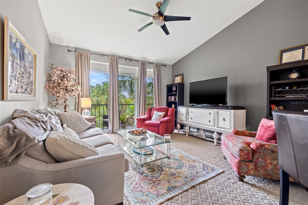 A living room features a sofa, two armchairs, a glass coffee table, and a balcony view — 1039 NORMANDY TRACE ROAD UNIT 1039, TAMPA, FL
