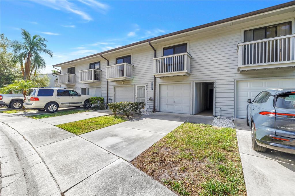 A row of two-story townhomes with attached garages, balconies, and concrete driveways — 6462 92ND PLACE N UNIT 803, PINELLAS PARK, FL